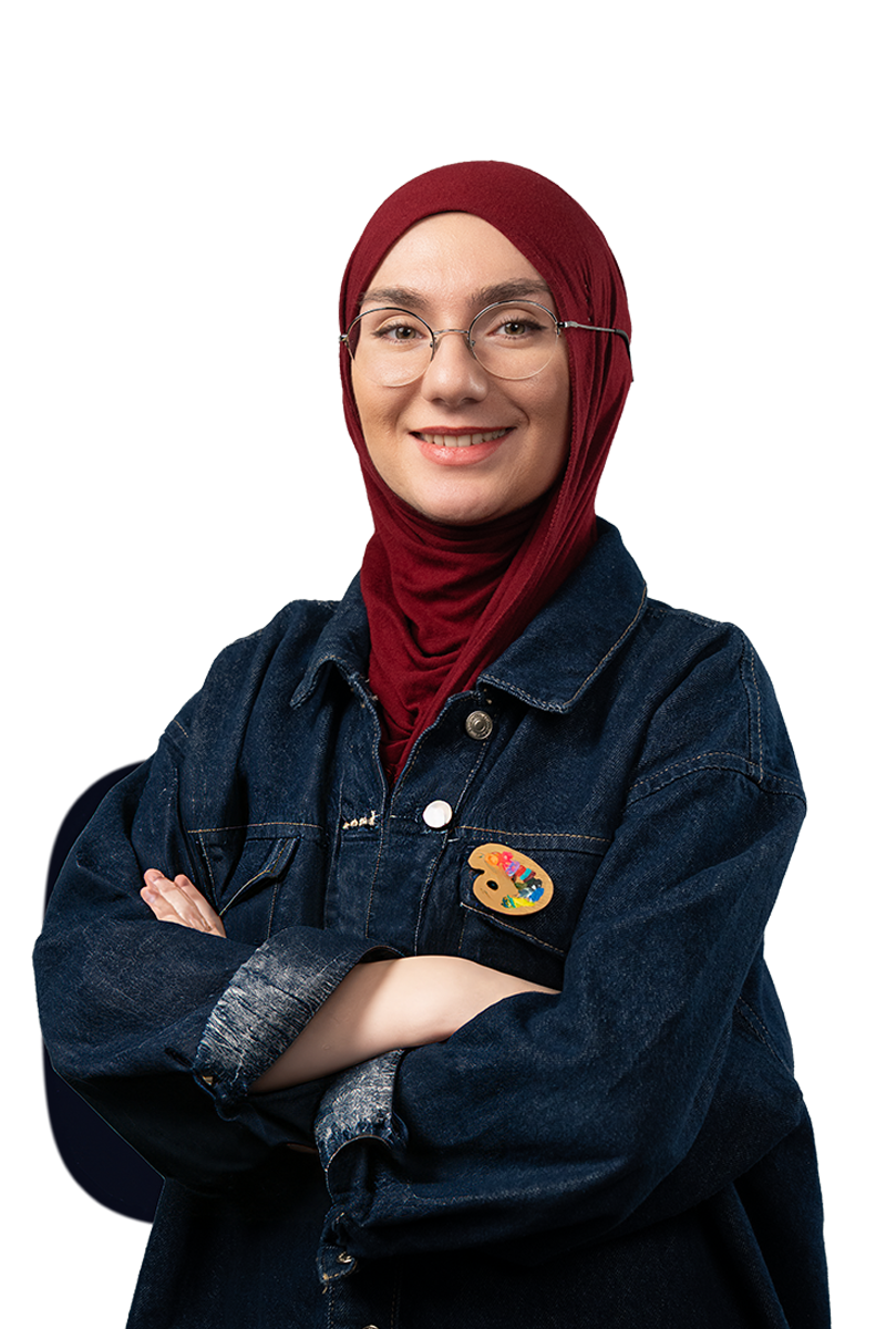 Smiling woman wearing glasses, a red hijab, and a dark denim jacket with a colorful artist palette pin, arms crossed.