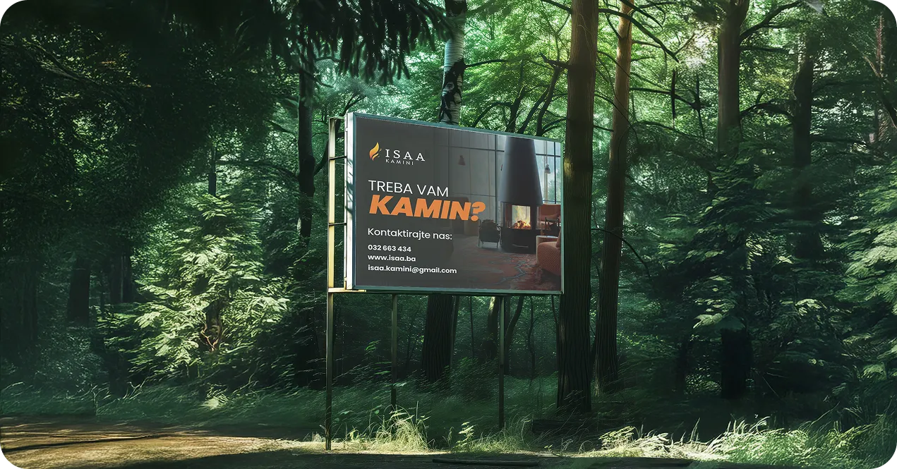 Billboard in a forest advertising ISAA Kamini with contact details and a photo of a modern indoor fireplace.