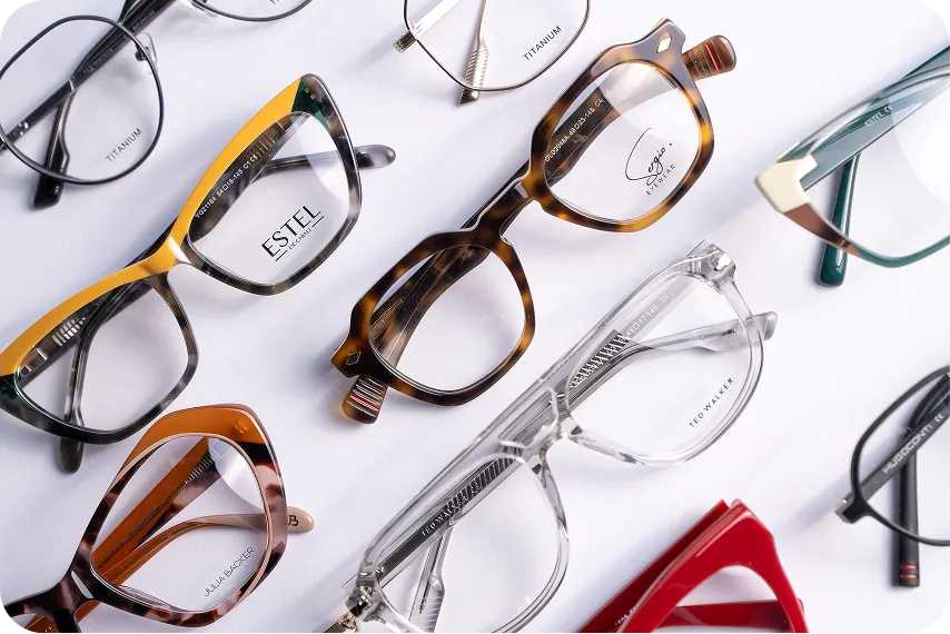 Variety of stylish eyeglasses with different frame shapes and colors laid out on a white surface.
