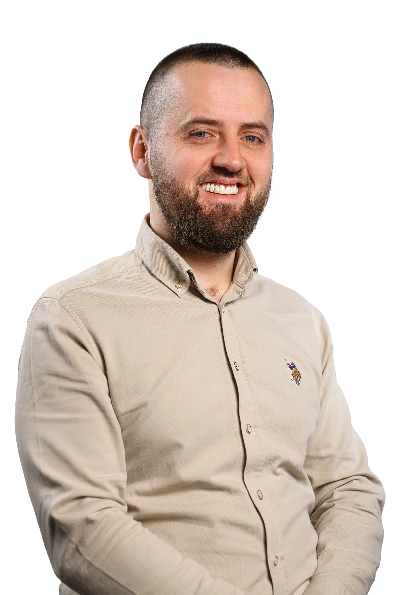 Smiling man with short hair and beard wearing a beige button-up shirt with a small embroidered logo.